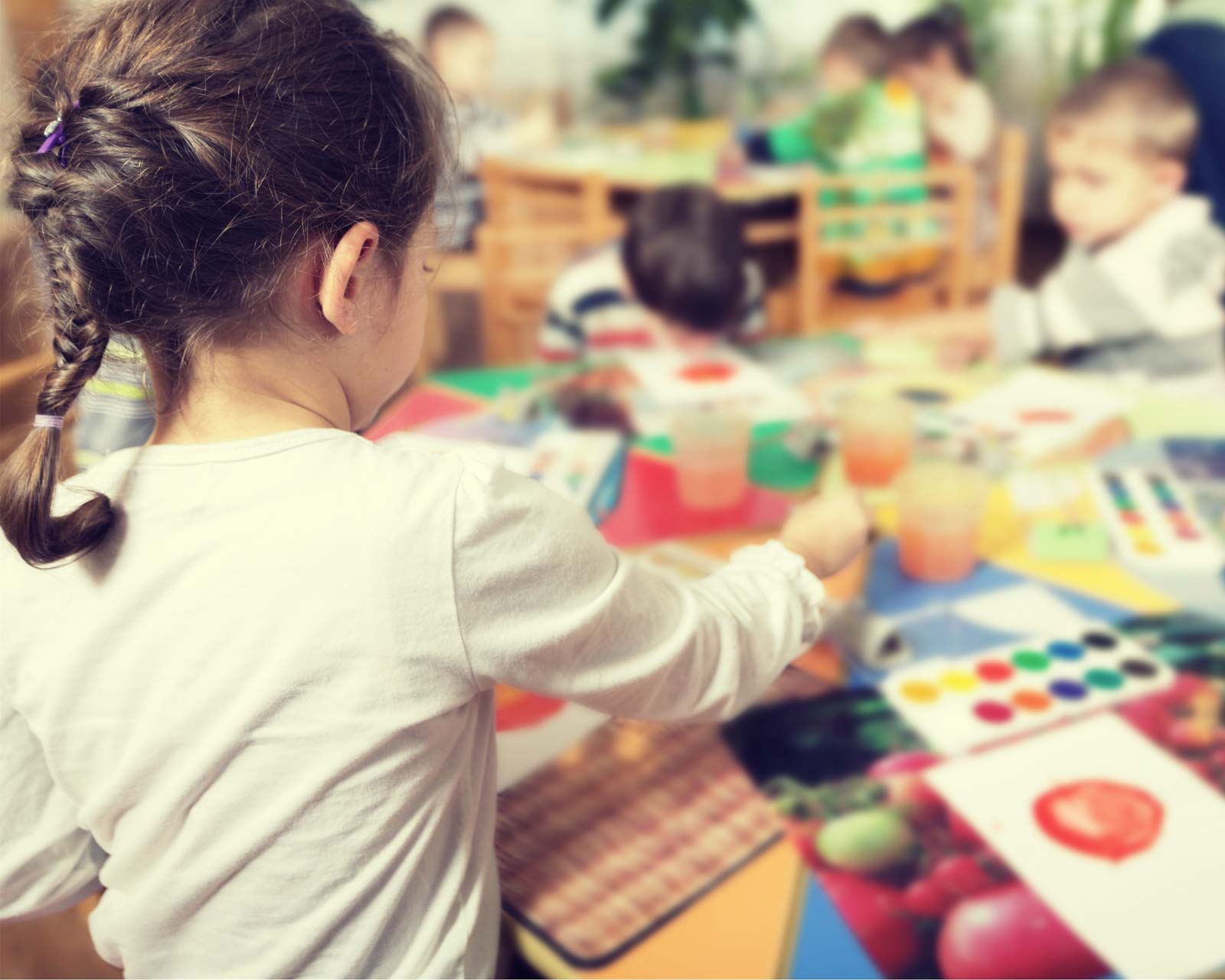 Une petite fille joue avec ses amis à la crèche